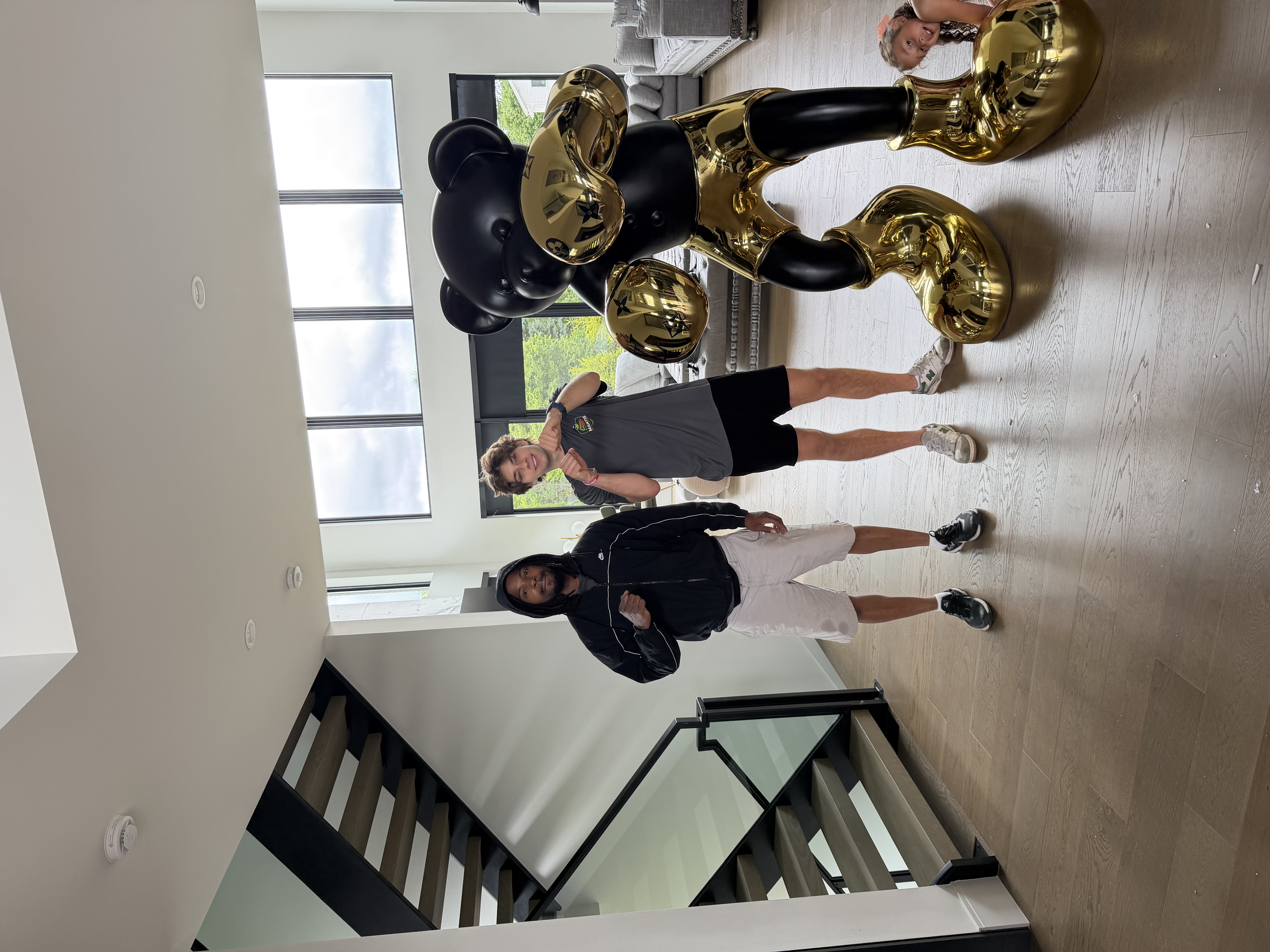 Mantis Moving crew members posing with large decorative black and gold statues inside a client's luxury home